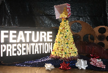 christmas tree on purple fabric with feature presentation sign in background