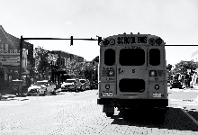 black and white picture of a school bus parked on a city street