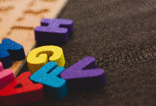 Red, blue, yellow, purple, letters on grey cloth
