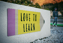 Pencil with love to learn on concrete sign