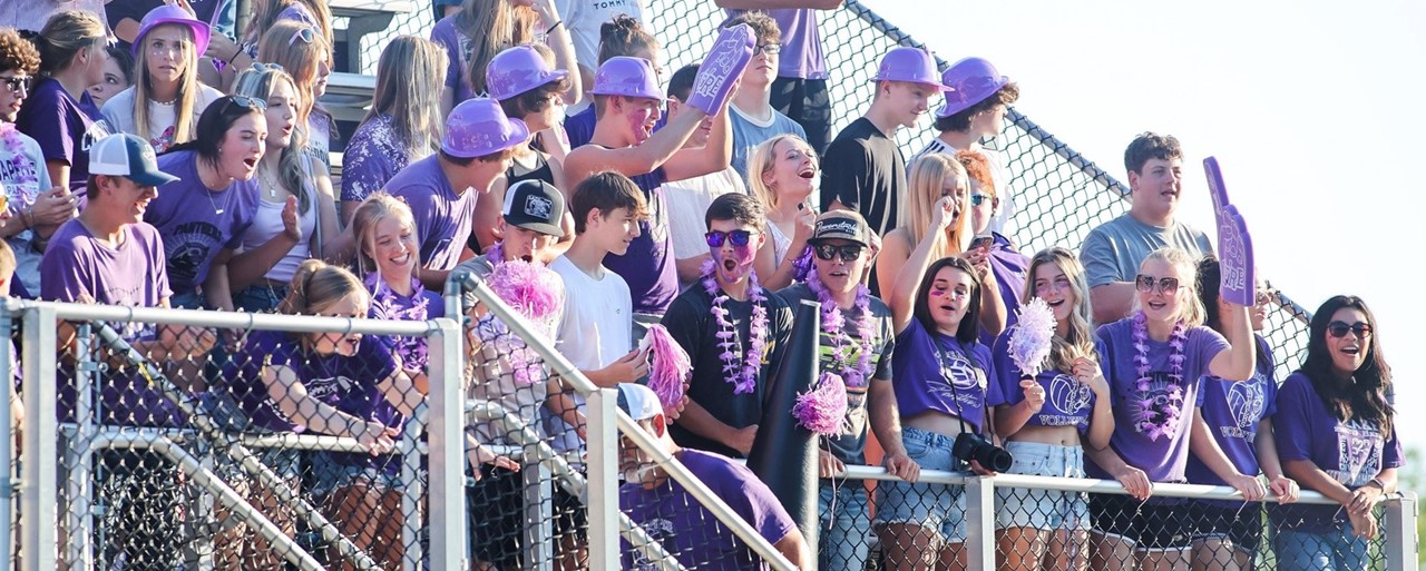 student section at football game wearing purple